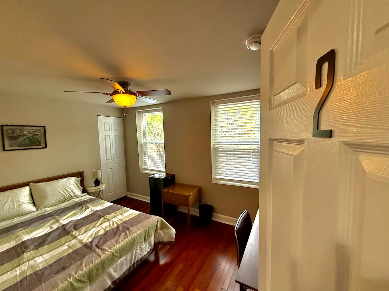 Spacious bedroom with ceiling fan and natural light