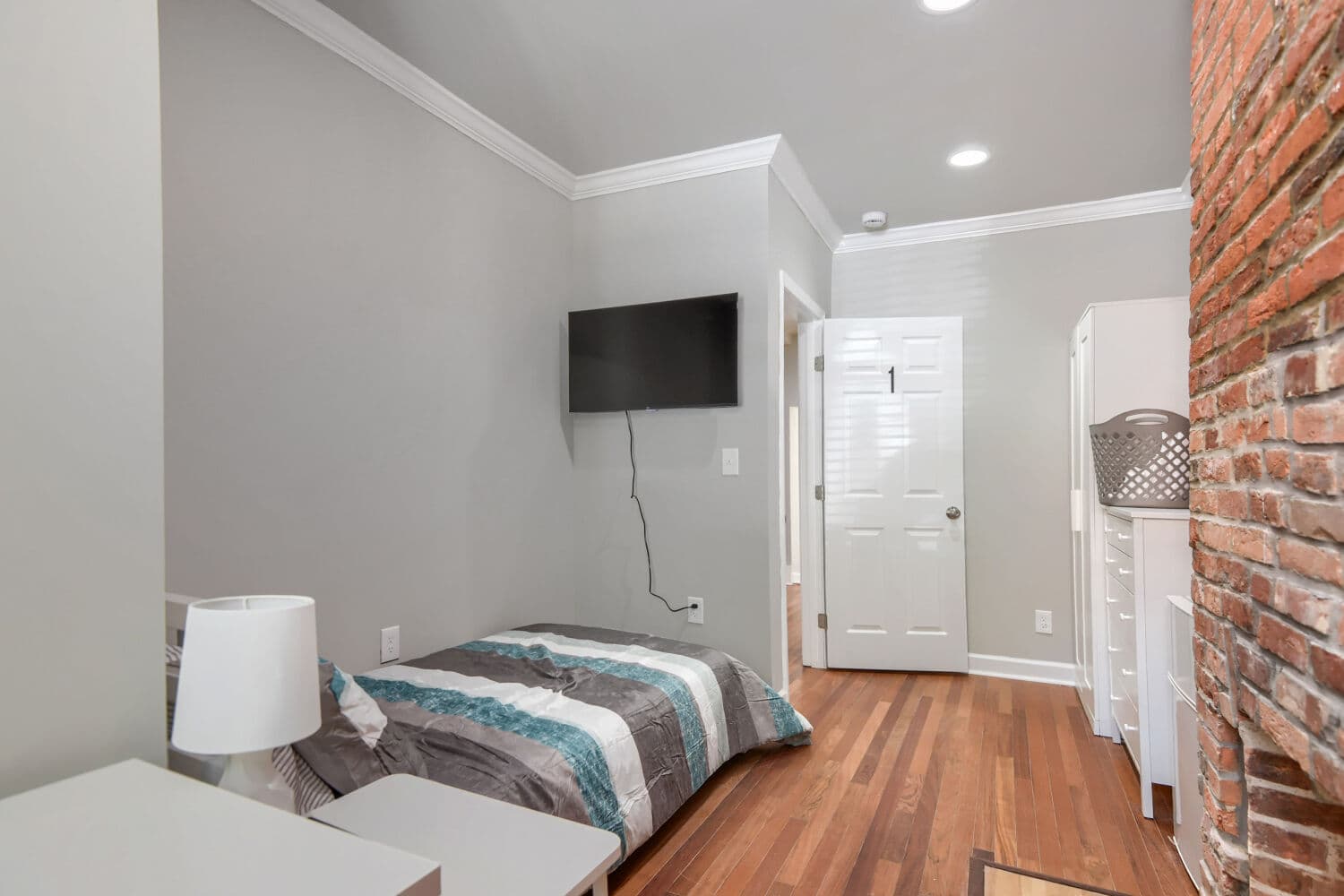 Bright bedroom with ceiling fan, closet, and tree-line window views